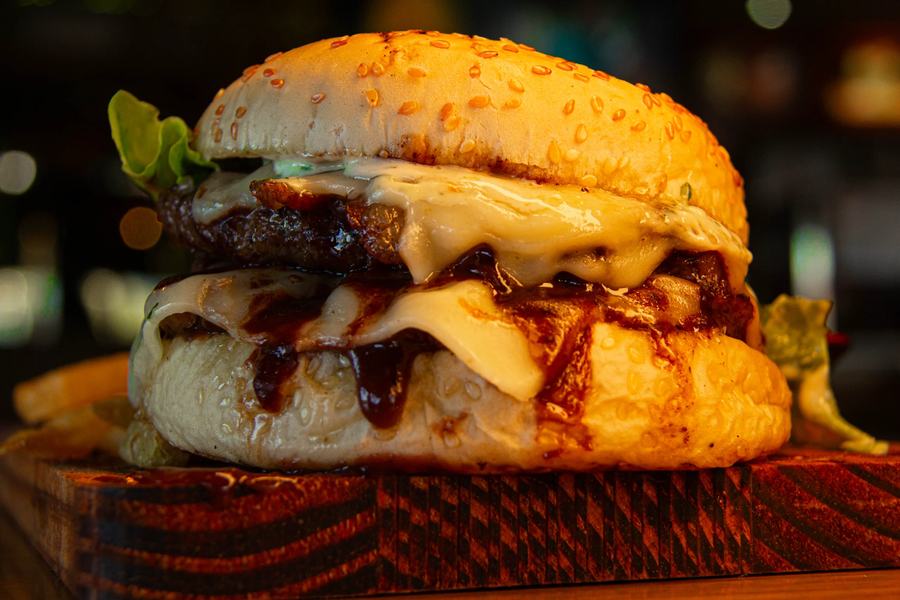Hambúrguer artesanal com queijo derretido e molho barbecue