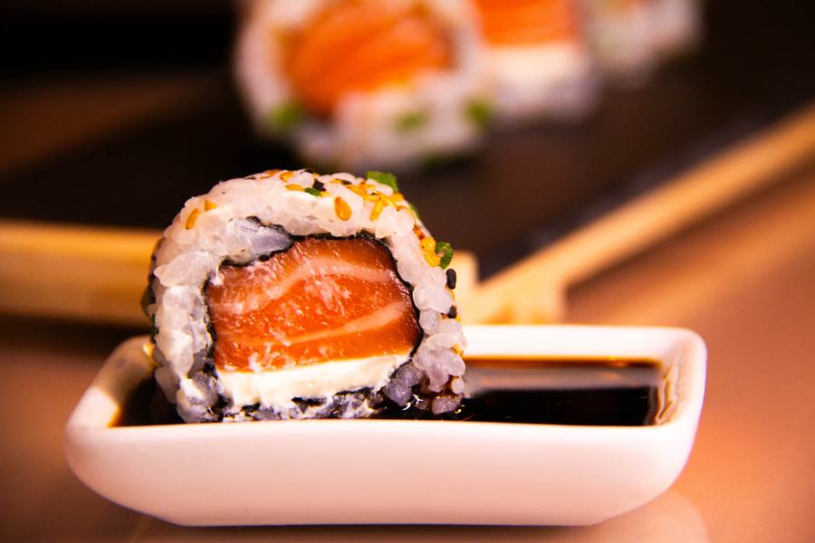 Sushi de salmão em detalhe, entre os hashis