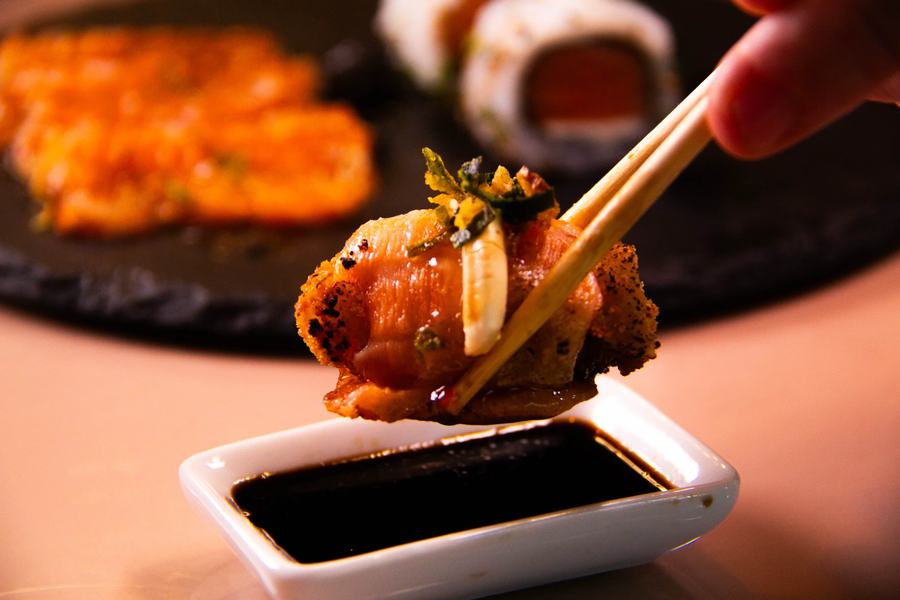Sushi empanado sendo servido com molho shoyu